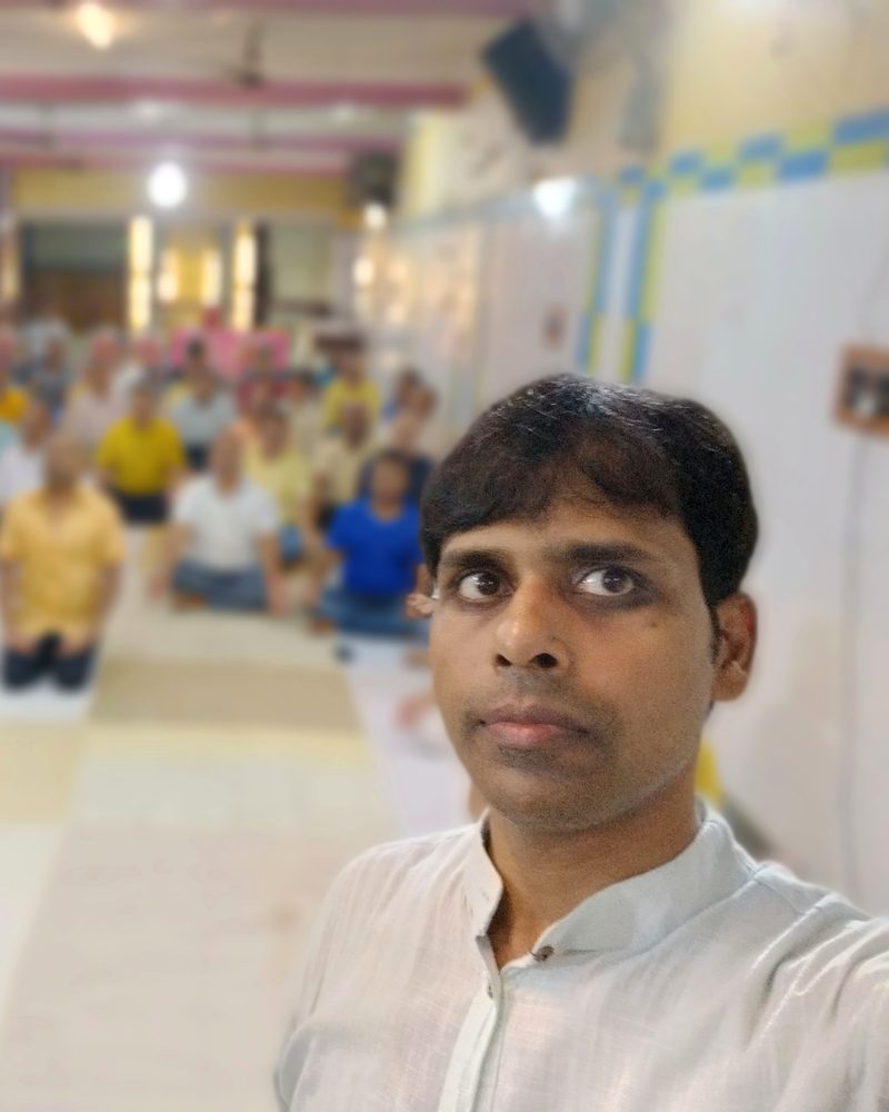 हर घर ध्यान कार्यक्रम में मुकेश जी, पीछे प्रतिभागियों से भरा हॉल