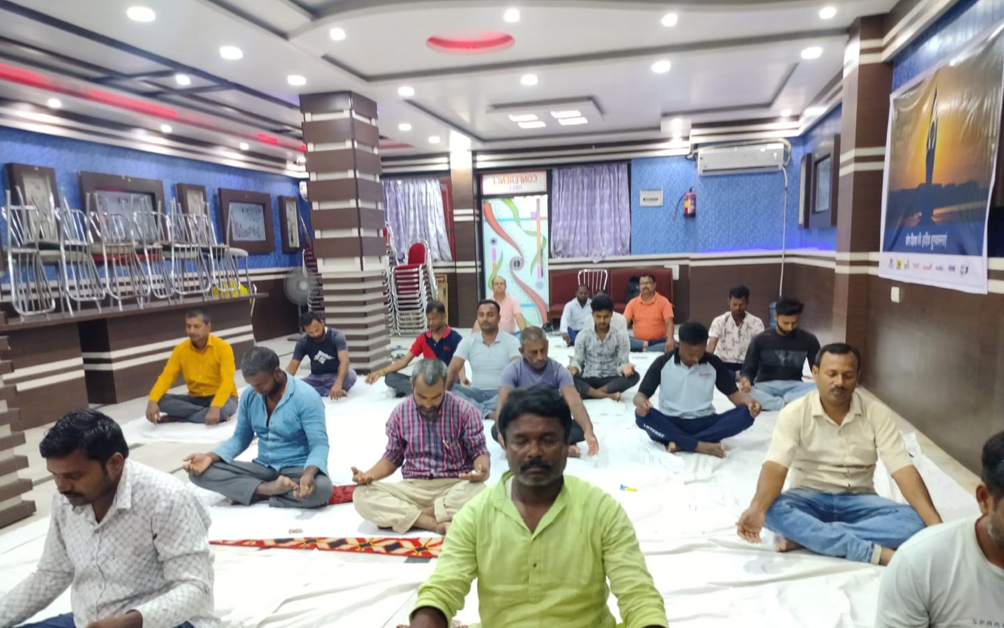 A full hall practising meditation at a yoga session in Muzaffarpur